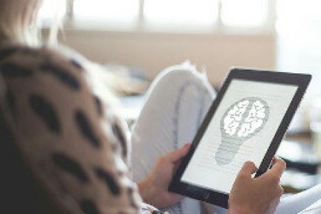 Eine Frau hält ein Tablet Computer mit dem Modell eines Gehirn