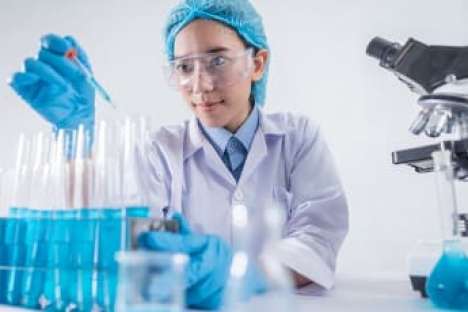 Ein Laborant nutzt eine Pipette und mehrere Reagenzgläser